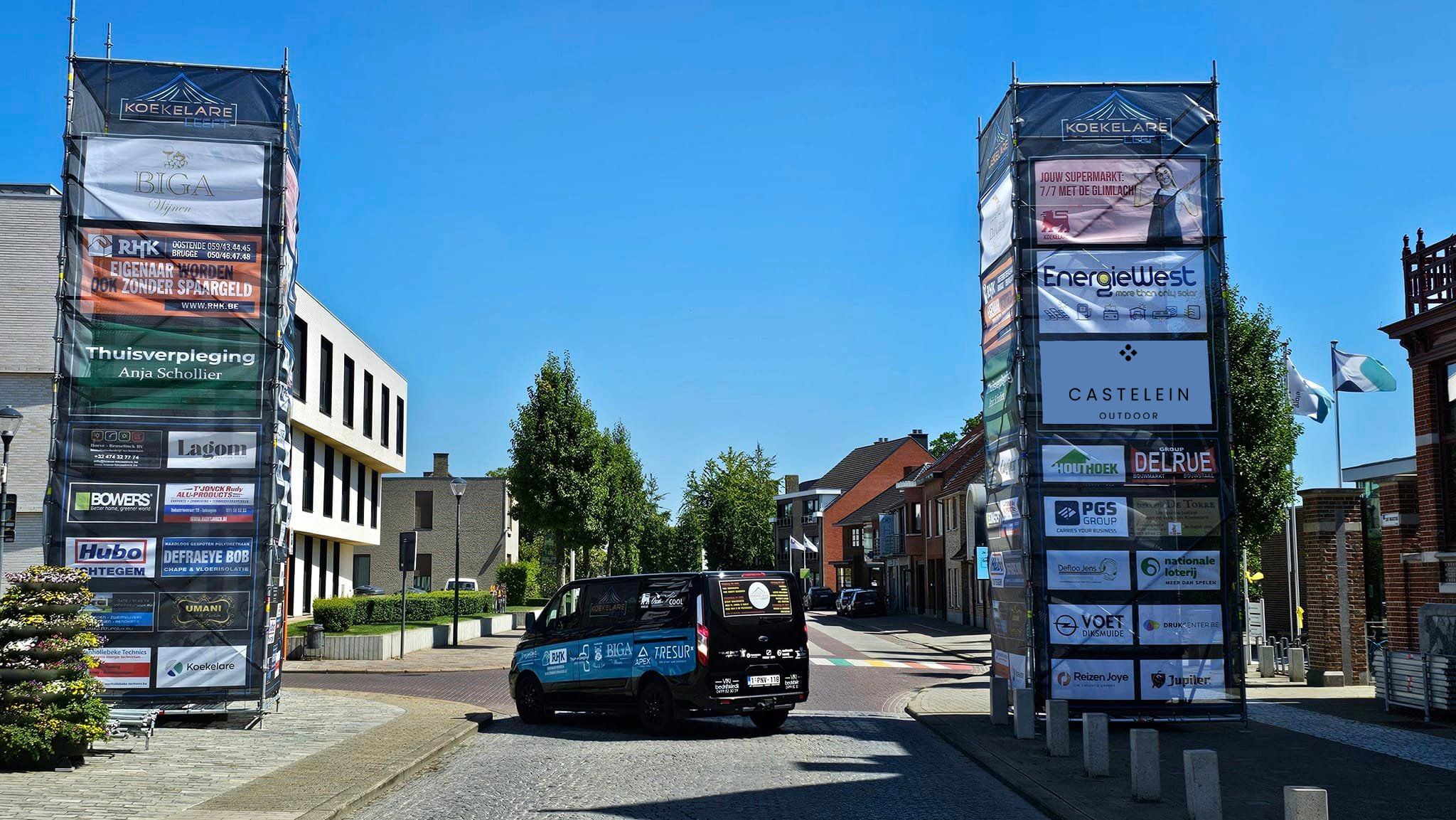 Sponsorborden bij de ingang van Koekelare Leeft, met het logo van Castelein Outdoor prominent aanwezig.