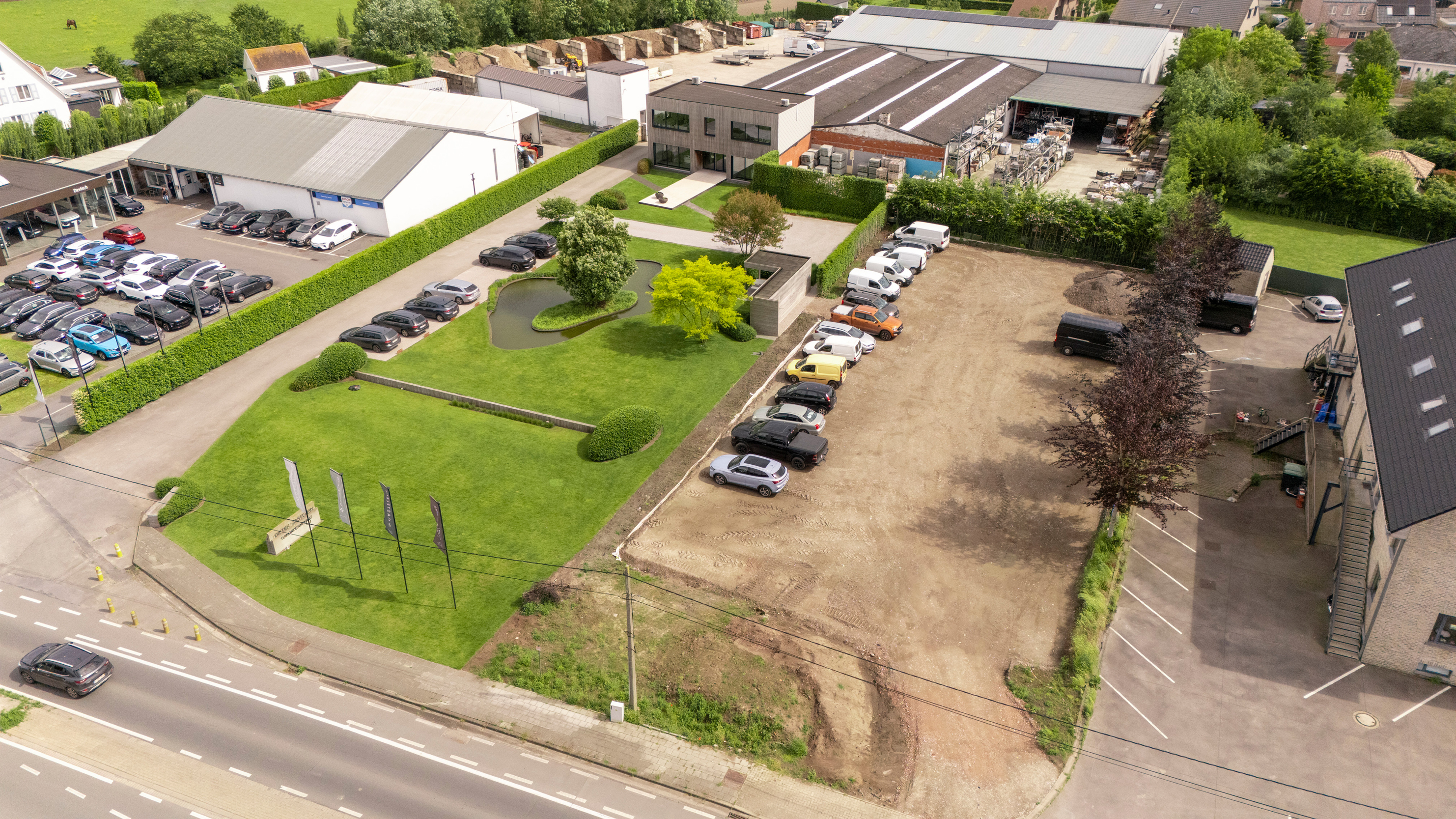 Luchtfoto van de nieuwe parkeerruimte bij Castelein Outdoor, met zowel auto's als groen in beeld.