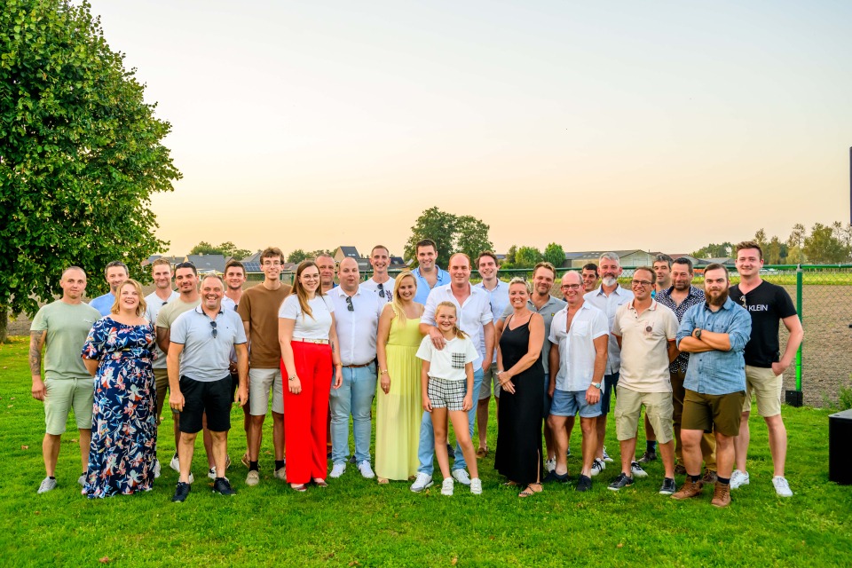 Groepsfoto van het team van Castelein Outdoor met hun familieleden tijdens de familiedag.