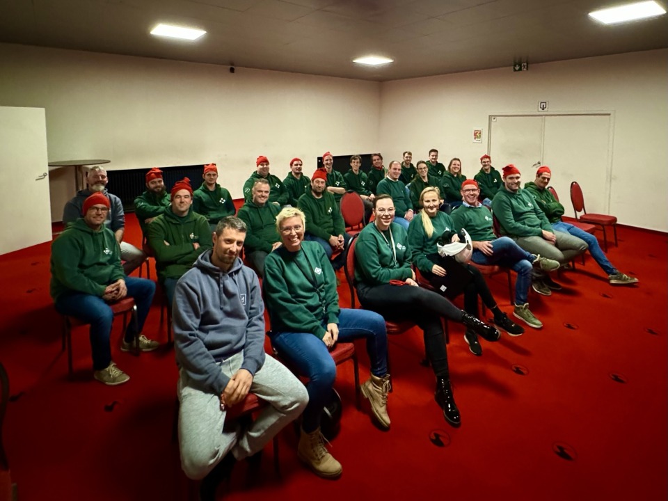 Groepsfoto van het team van Castelein Outdoor, zittend in een kartbaan, klaar voor de race.