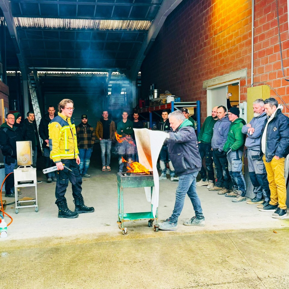 Medewerkers van Castelein Outdoor volgen aandachtig een demonstratie tijdens de brand- en EHBO-opleiding.