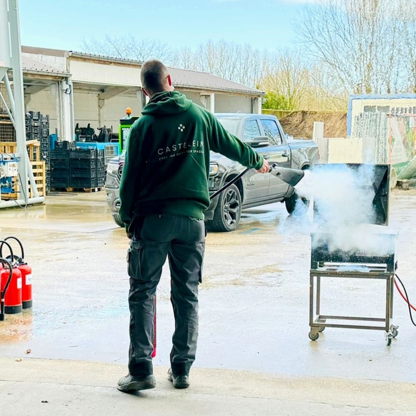 Medewerker van Castelein Outdoor blust een oefenbrand tijdens de Brand- en EHBO-training.