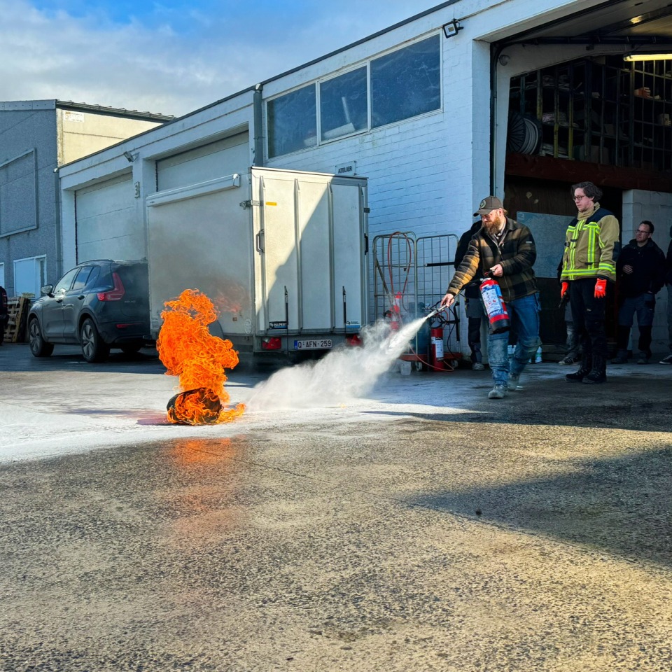 Demonstratie van het blussen van een oefenbrand tijdens de opleiding.