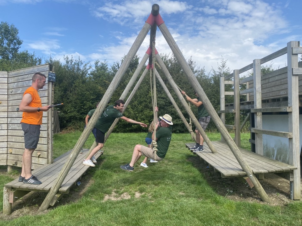 Collega's werken samen op een schommelconstructie als onderdeel van de opdrachten.