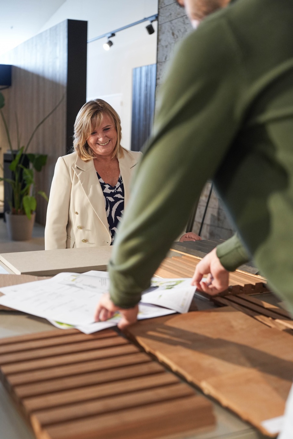 klant kiest tussen verschillende houtsoorten in de showroom van castelein outdoor