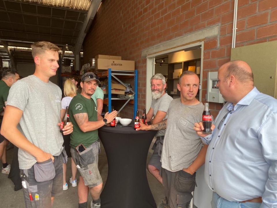 Teamleden lachen en genieten van hun maaltijd tijdens het bouwverlof.